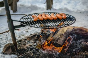 Campfire with sausages cooking on top