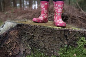 Girl walking in a forest with wellington boots